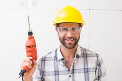 Construction worker holding power drill in a new house