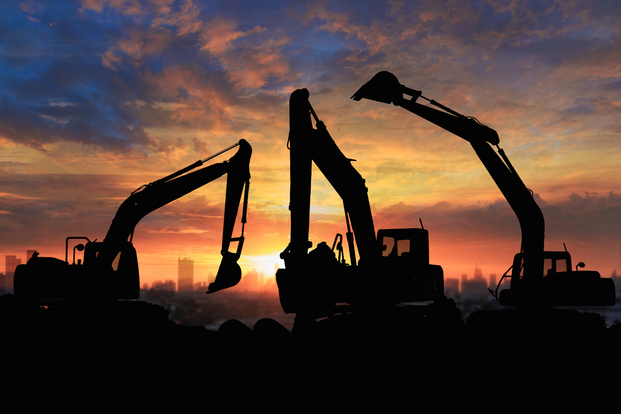 Crawler excavators silhouette at construction site